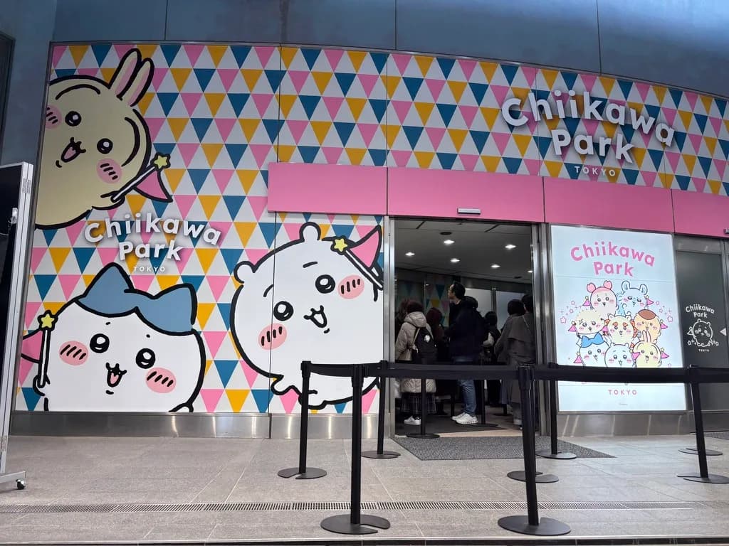 Chiikawa Park TOKYO 的入口,彩色三角形的牆面上畫著吉伊卡哇、小八和烏薩奇,門口排著隊